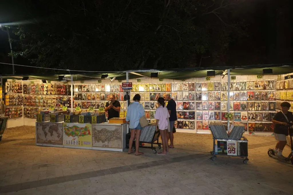 Bodrum Kitap ve Edebiyat Fuarı’nda gece plak ve afiş standını gezen ziyaretçiler.