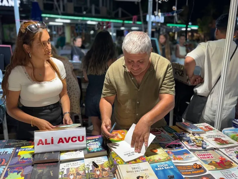 Bodrum Kitap ve Edebiyat Fuarı’nda imza günü; yazar Ali Avcu kitap imzalarken.